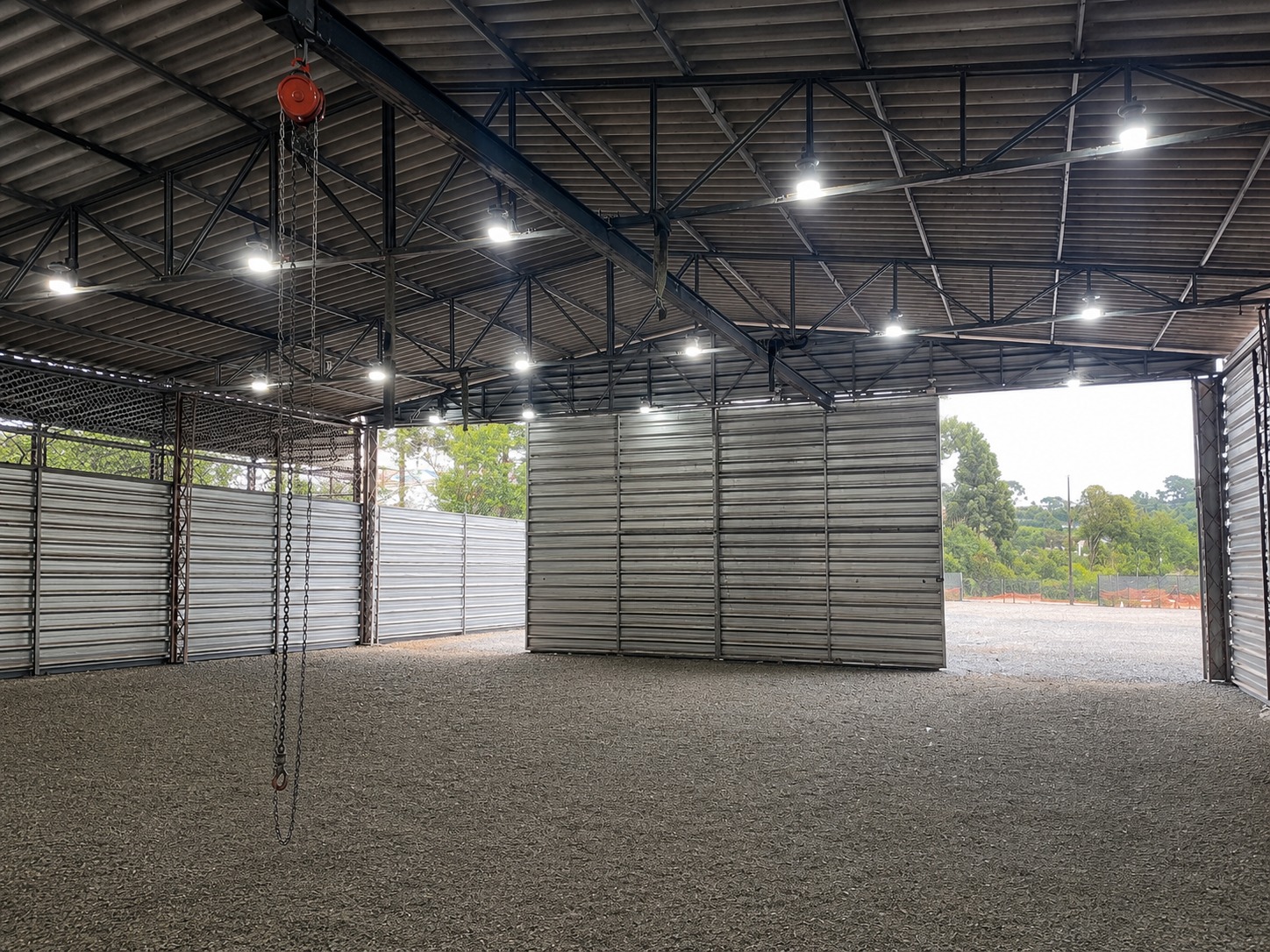 Galpão industrial com luminárias em linha instaladas na estrutura metálica do telhado