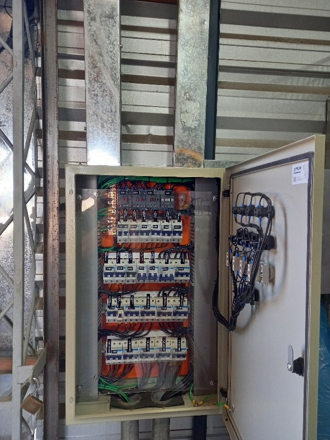 Painel elétrico aberto com disjuntores e barramento instalados em estrutura industrial